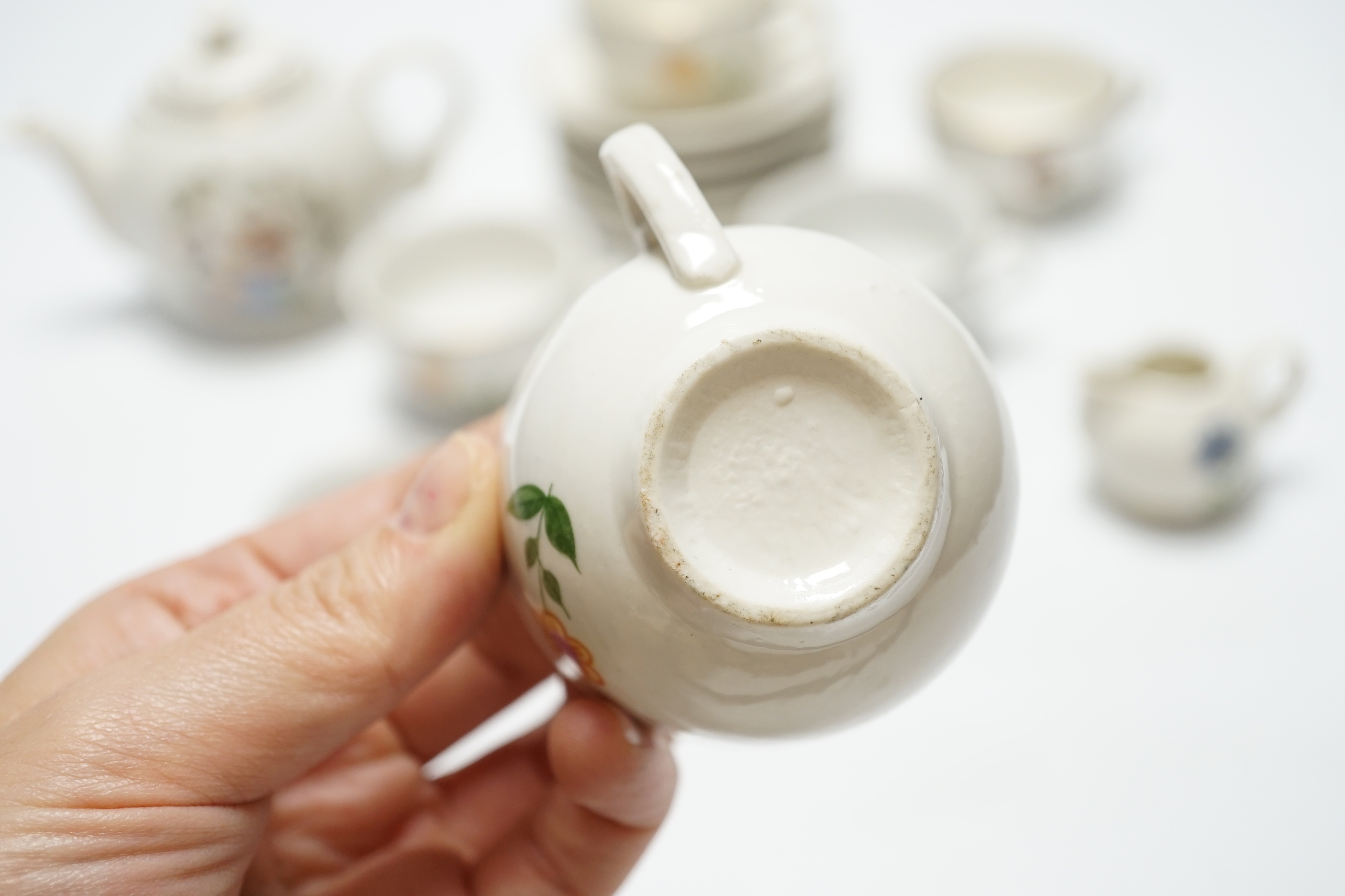 A child’s tea set comprising a teapot, five cups and saucers and a milk jug, teapot 8.5cm